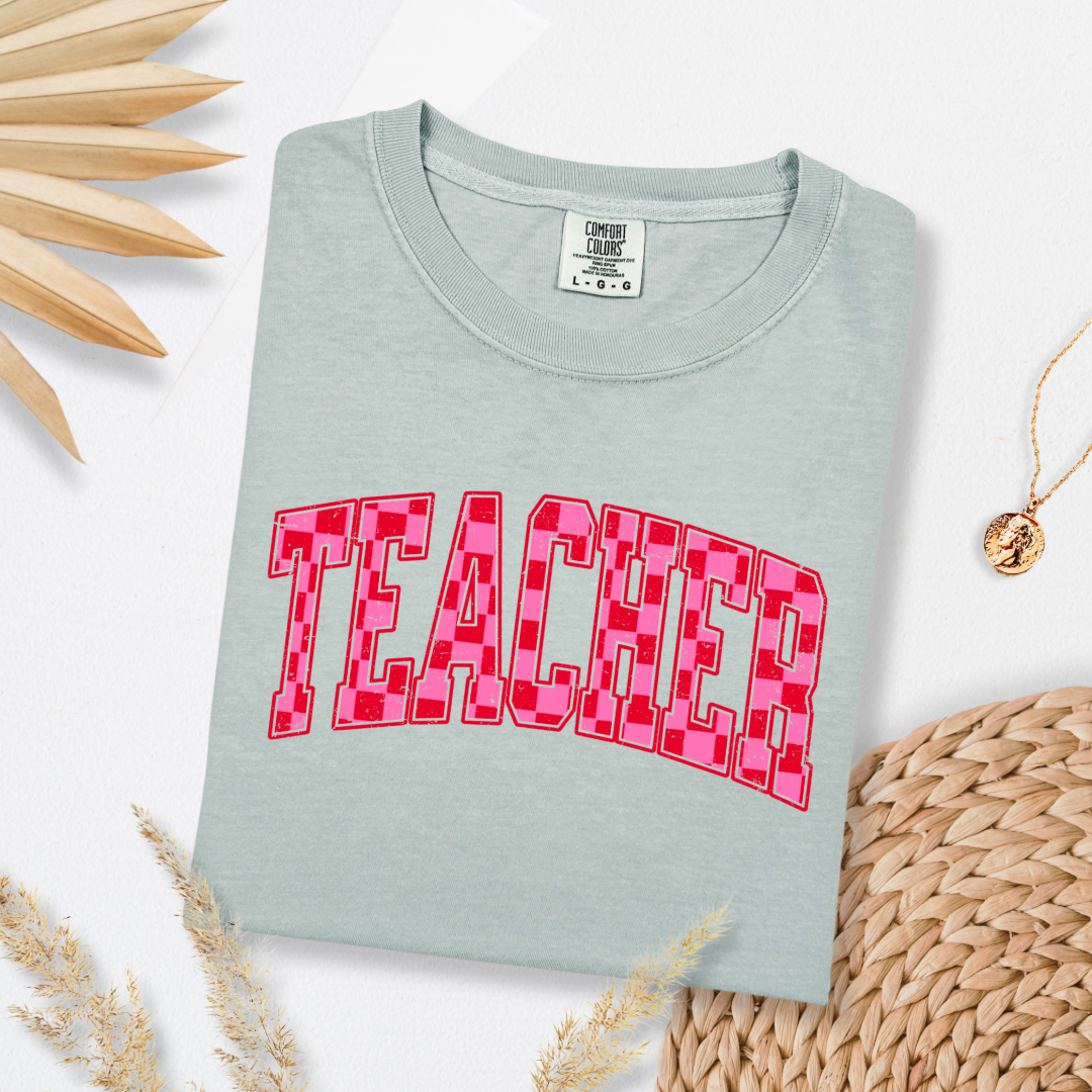 Customized Adult Bay Green Graphic tee with pink and red checkered teacher varsity font.