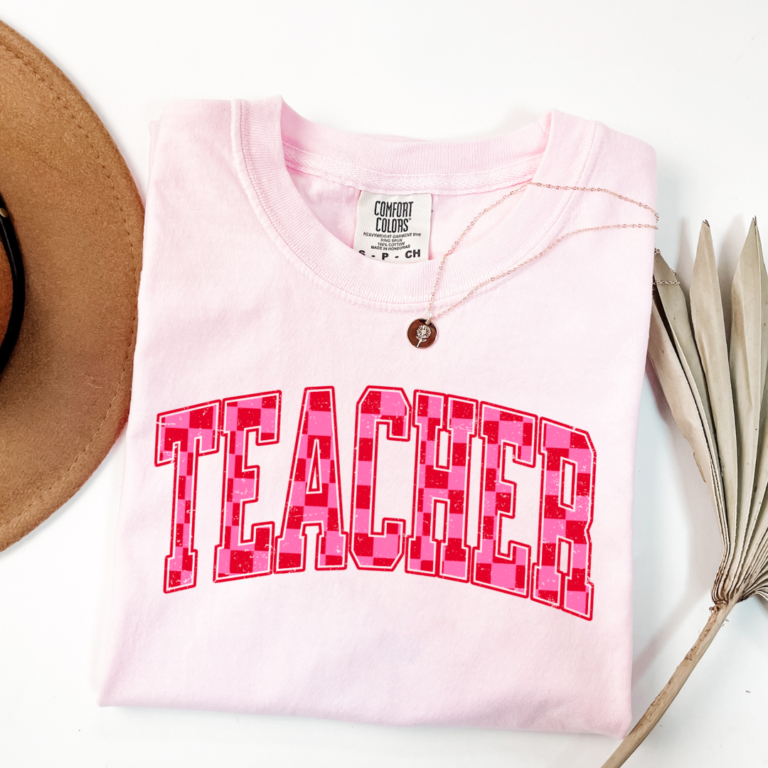 Customized Adult Blossom Pink Graphic tee with pink and red checkered teacher varsity font.