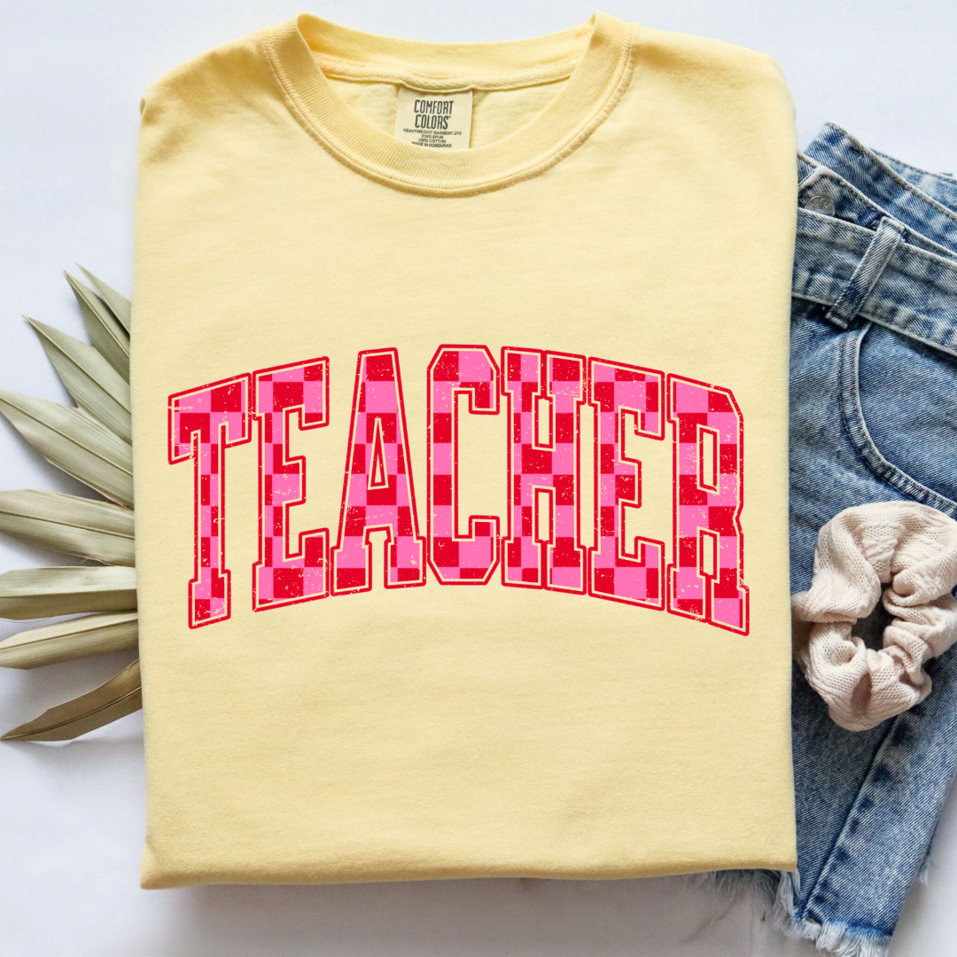 Customized Adult Butter Yellow Graphic tee with pink and red checkered teacher varsity font.