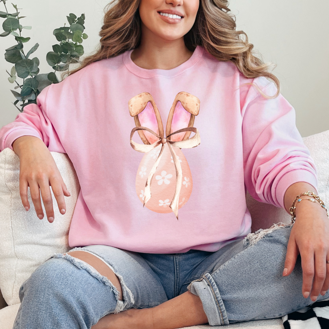 Customized adult light pink crewneck watercolor peach egg with white flowers and brown floppy skinny bow and bunny ears matching tees and hoodies available in adult and youth sizes