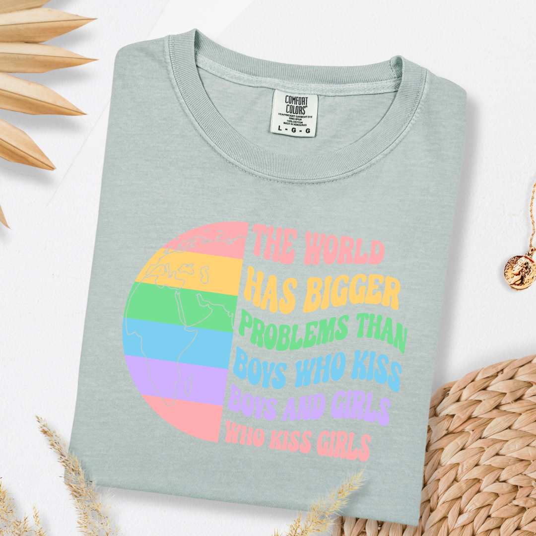 Customized Adult comfort colorsBay Green Graphic tee. Split image rainbow world map on one side and quote " the world has bigger problems than boys who kiss boys. and girls who kiss girls" on the other matching adult crewnecks and hoodies available. Perfect for Pride month,