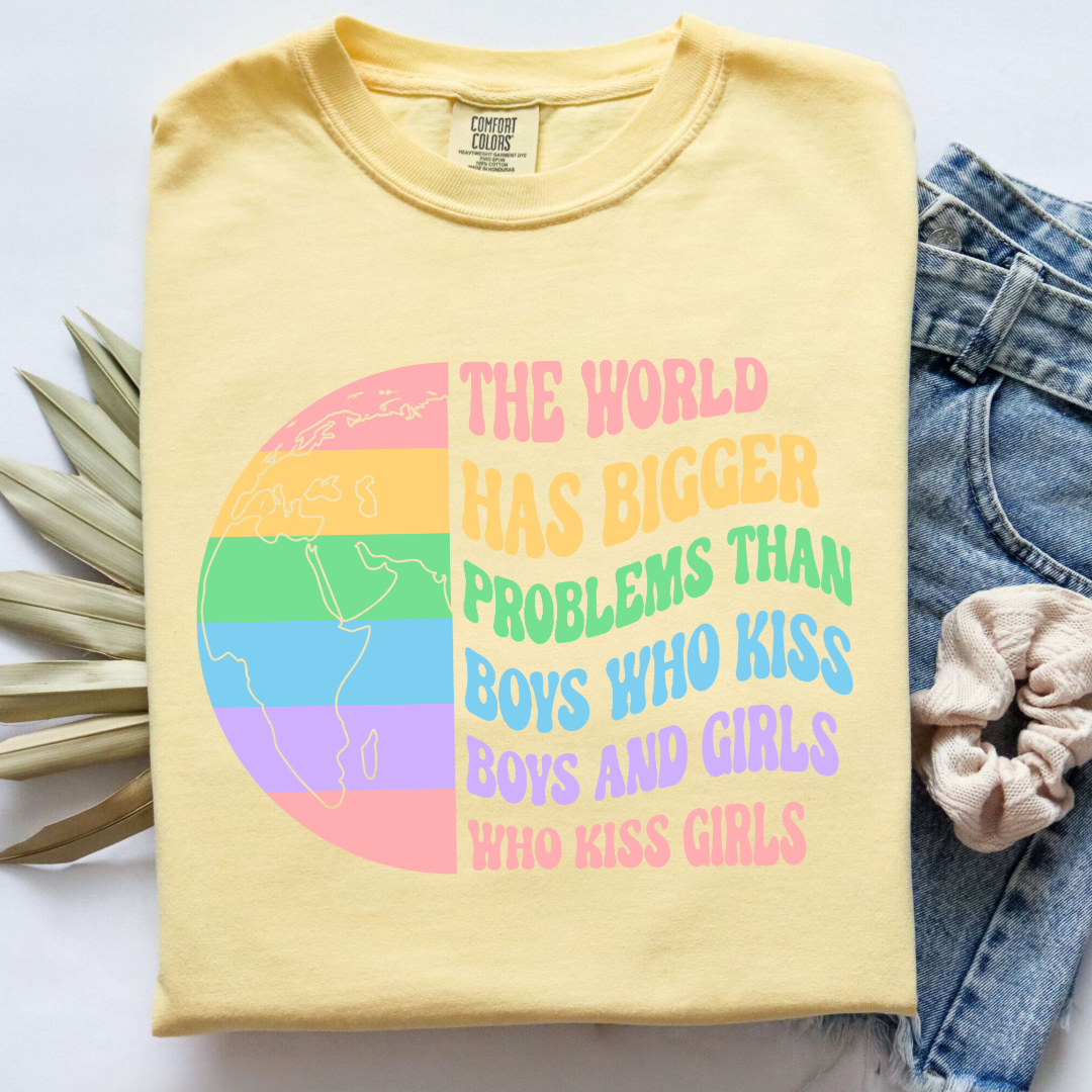 Customized Adult comfort colors Butter Yellow Graphic tee. Split image rainbow world map on one side and quote " the world has bigger problems than boys who kiss boys. and girls who kiss girls" on the other matching adult crewnecks and hoodies available. Perfect for Pride month,