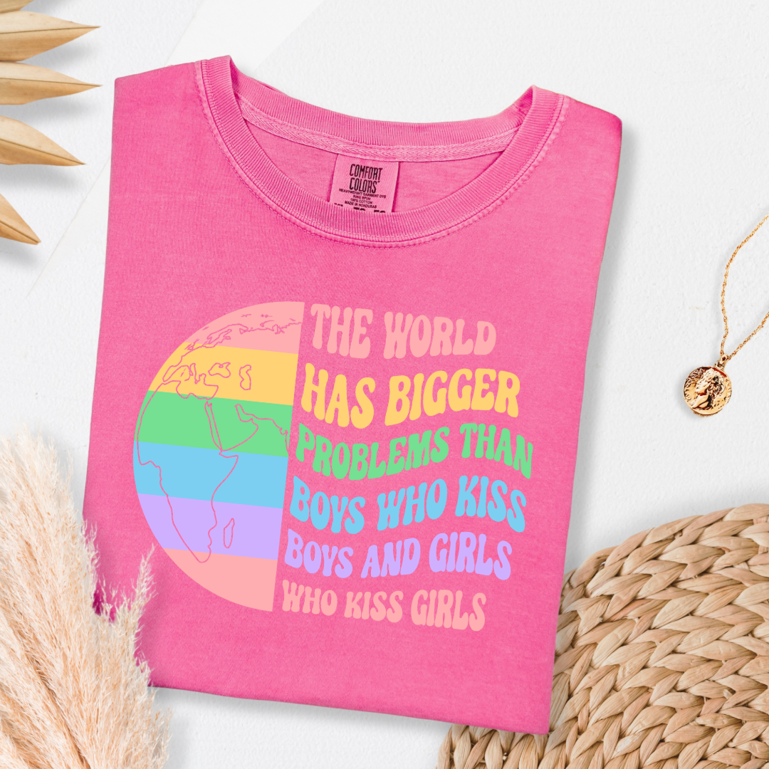 Customized Adult comfort colors Crunchberry Pink Graphic tee. Split image rainbow world map on one side and quote " the world has bigger problems than boys who kiss boys. and girls who kiss girls" on the other matching adult crewnecks and hoodies available. Perfect for Pride month,
