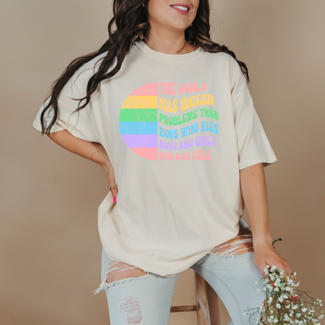 Customized Adult comfort colors Ivory Graphic tee. Split image rainbow world map on one side and quote " the world has bigger problems than boys who kiss boys. and girls who kiss girls" on the other matching adult crewnecks and hoodies available. Perfect for Pride month,