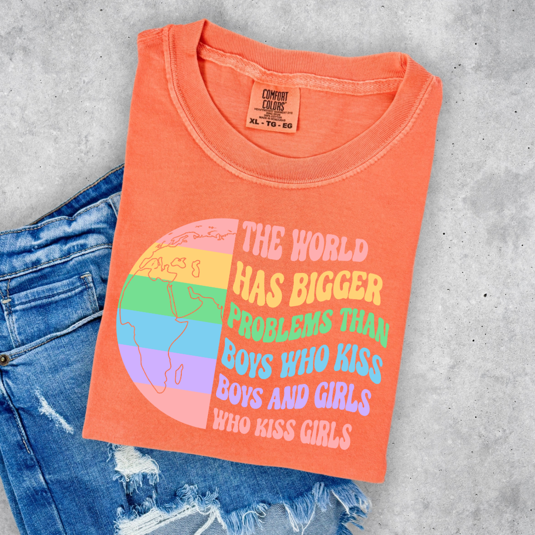 Customized Adult comfort colorsMelon orange Graphic tee. Split image rainbow world map on one side and quote " the world has bigger problems than boys who kiss boys. and girls who kiss girls" on the other matching adult crewnecks and hoodies available. Perfect for Pride month,