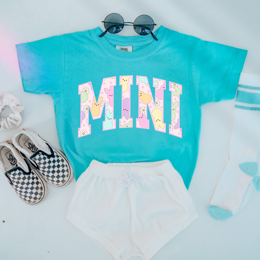 Customized youth mini of a mama and mini matching set varsity lettering with Patel peeps on the inside of the lettering matching youth crewnecks available comfort colors lagoon blue graphic tee
