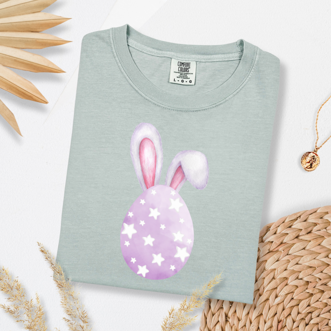 Customized adult comfort colors bay green graphic tee with purple watercolor egg with white stars matching crewneck and hoodies available in youth and adult sizes