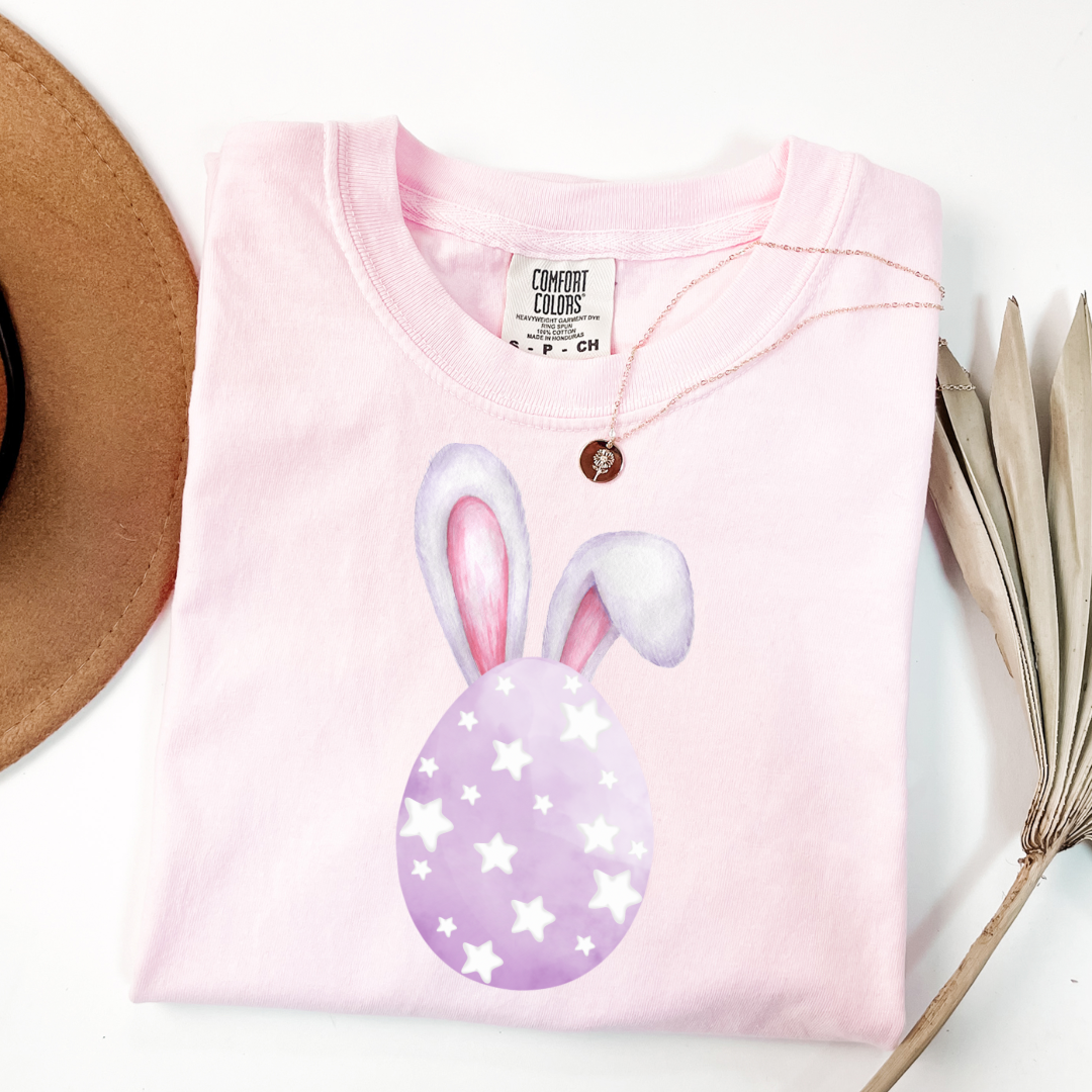 Customized adult comfort colors blossom pink graphic tee with purple watercolor egg with white stars matching crewneck and hoodies available in youth and adult sizes