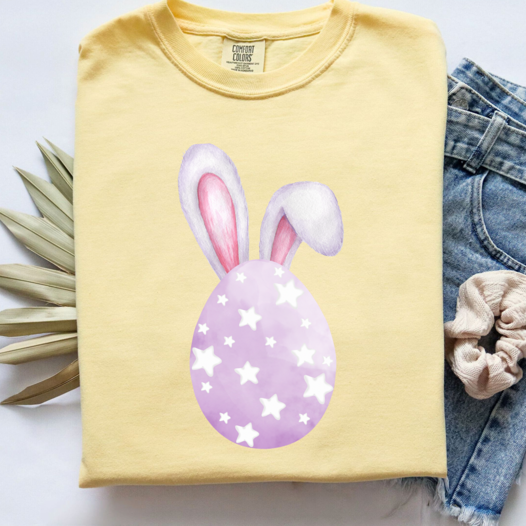Customized adult comfort colors butter yellow graphic tee with purple watercolor egg with white stars matching crewneck and hoodies available in youth and adult sizes
