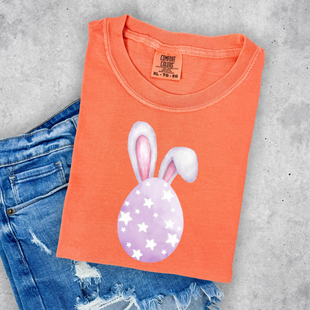 Customized adult/youth comfort colors melon orange graphic tee with purple watercolor egg with white stars matching crewneck and hoodies available in youth and adult sizes
