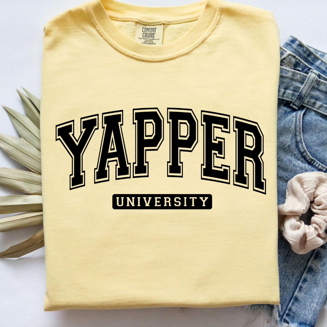 Customized adult comfort colors Butter yellow Graphic tee with black varsity lettering yapper university Matching hoodies and crewnecks in adult and youth sizes available.