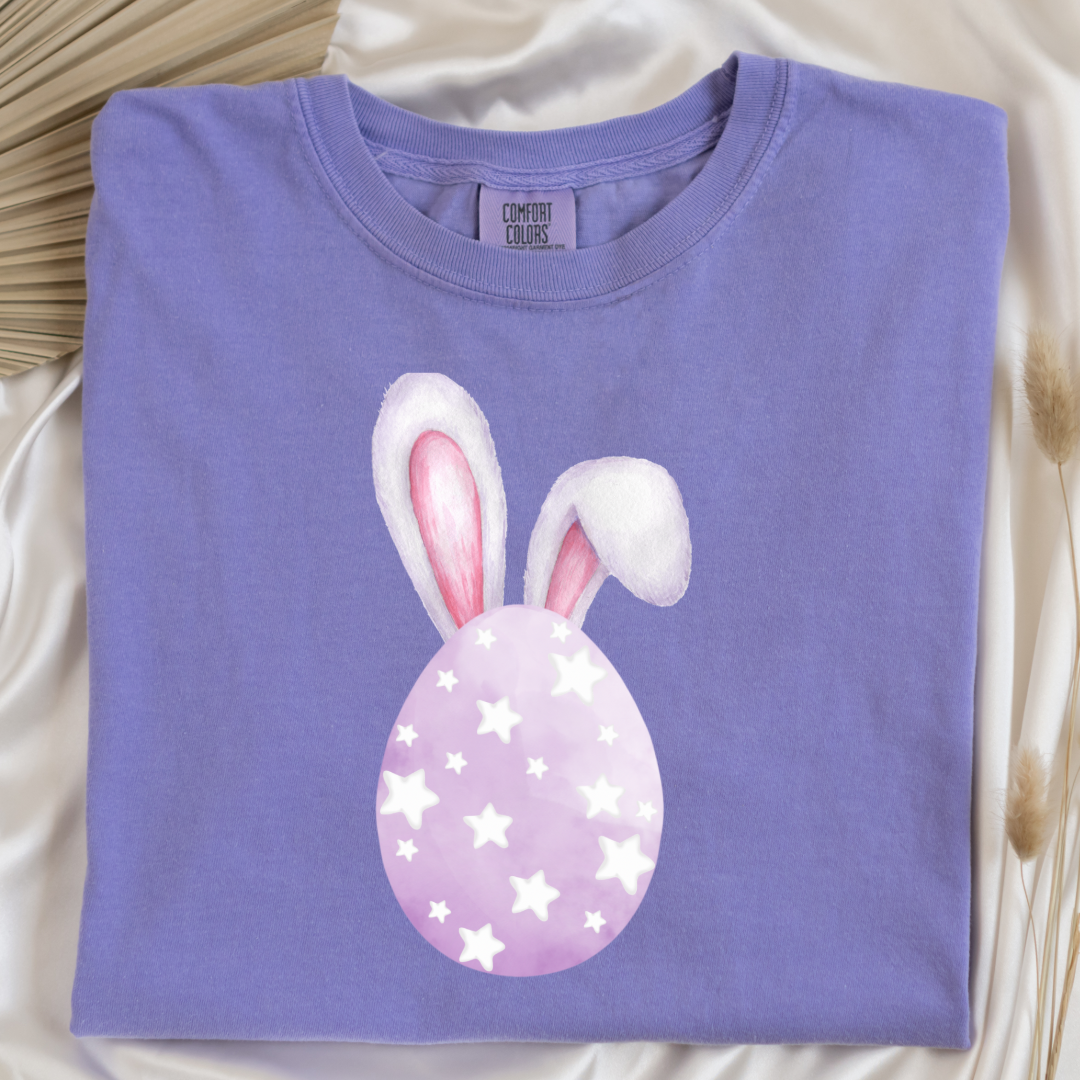 Customized adult comfort colors violet graphic tee with purple watercolor egg with white stars matching crewneck and hoodies available in youth and adult sizes