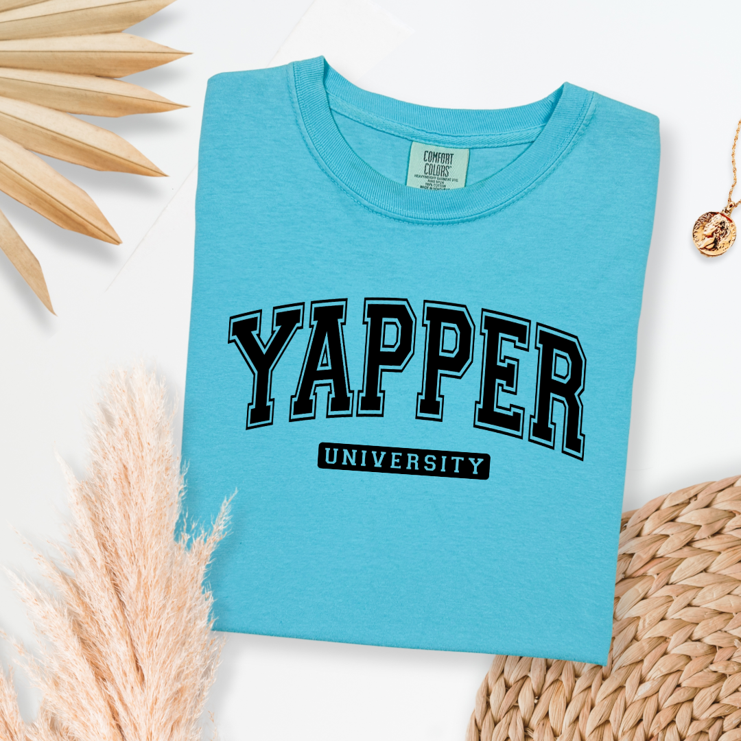 Customized adult comfort colors Lagoon Blue Graphic tee with black varsity lettering yapper university Matching hoodies and crewnecks in adult and youth sizes available.