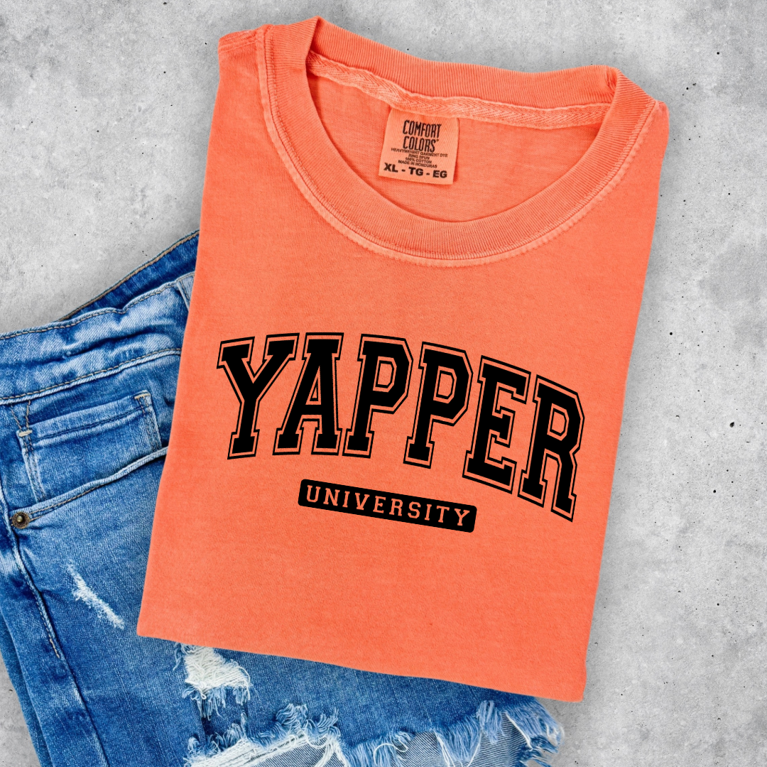 Customized adult/youth comfort colors Melon Orange Graphic tee with black varsity lettering yapper university Matching hoodies and crewnecks in adult and youth sizes available.