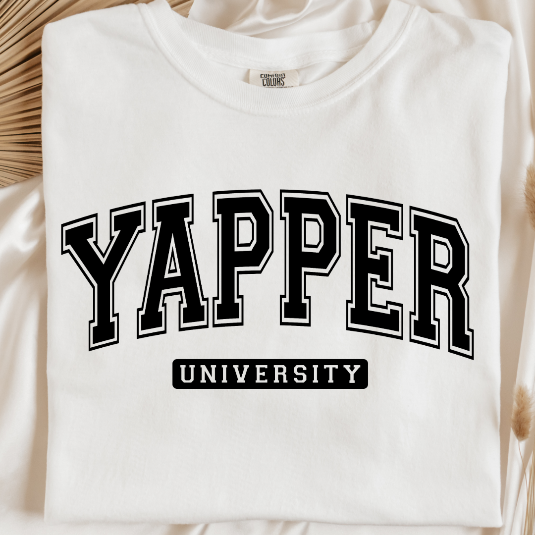 Customized adult comfort colors white Graphic tee with black varsity lettering yapper university Matching hoodies and crewnecks in adult and youth sizes available.