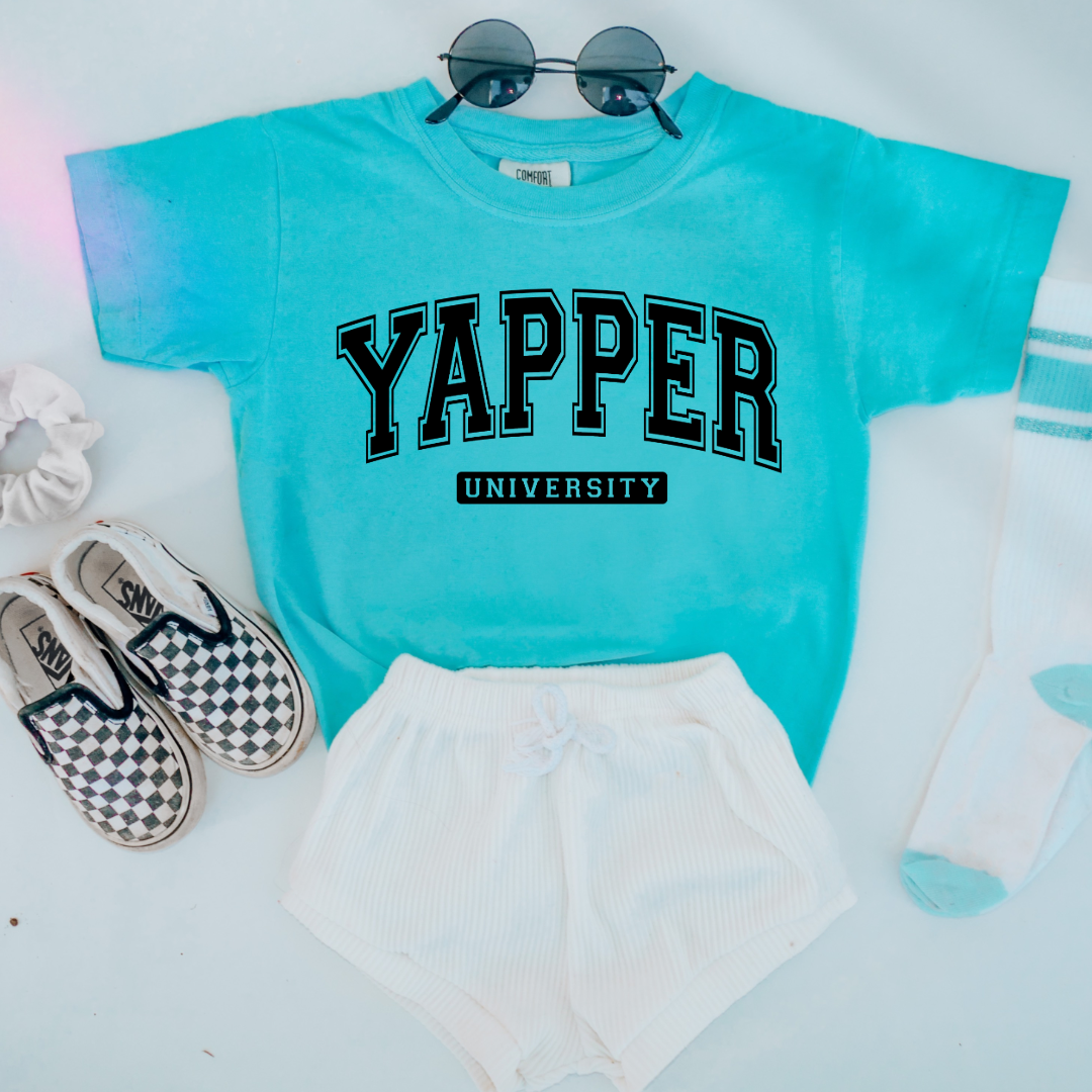 Customized Youth comfort colors Lagoon Blue Graphic tee with black varsity lettering yapper university Matching hoodies and crewnecks in adult and youth sizes available.