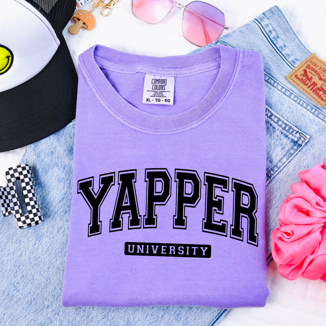 Customized Youth comfort colors Violet Graphic tee with black varsity lettering yapper university Matching hoodies and crewnecks in adult and youth sizes available.