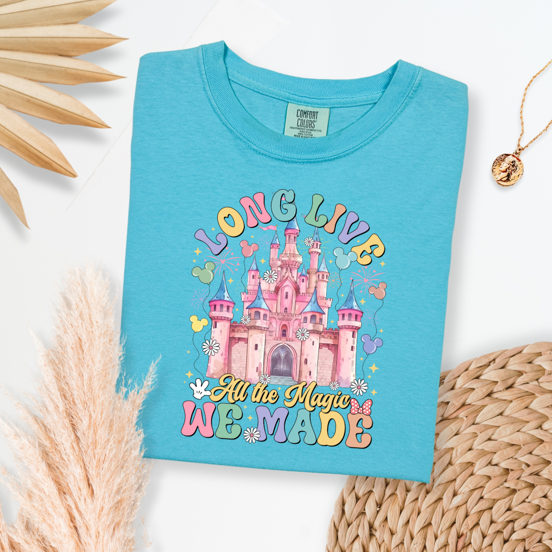 Customized adult comfort colors lagoon blue t-shirt with long live multi color long live bubble letters large castle in the middle with Mickey Mouse shaped balloons and flowers surrounding. Matching crewnecks and hoodies available in youth and adult sizes