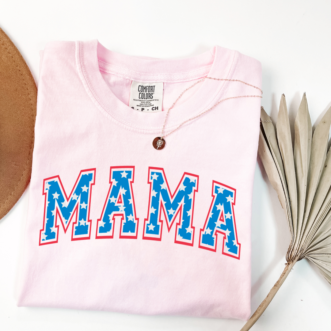 Customized adult Comfort Colors Blossom Pink Graphic Tee with Seasonal 4th of July University style Font MAMA blue with white stars outlined un red , This style is available in adult Graphic Tees as well as adult crewnecks and hoodies .Available In DAD, MAMA and MINI.