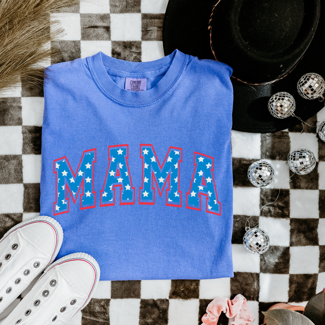 Customized adult Comfort Colors Flo Blue Graphic Tee with Seasonal 4th of July University style Font MAMA blue with white stars outlined un red , This style is available in adult Graphic Tees as well as adult crewnecks and hoodies .Available In DAD, MAMA and MINI.