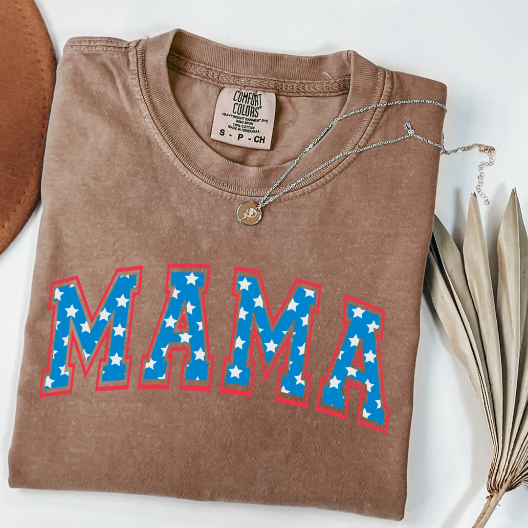 Customized adult Comfort Colors Espresso Brown Graphic Tee with Seasonal 4th of July University style Font MAMA blue with white stars outlined un red , This style is available in adult Graphic Tees as well as adult crewnecks and hoodies .Available In DAD, MAMA and MINI.