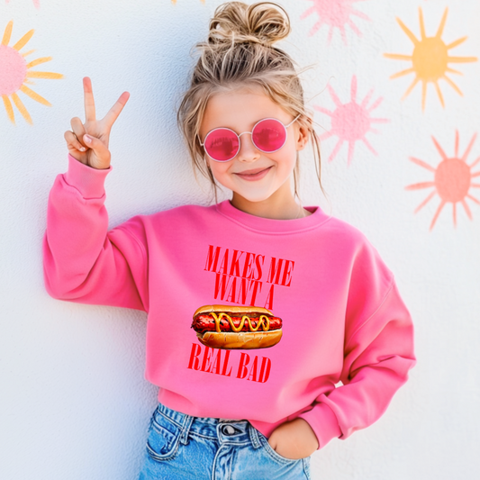 Customized Youth Hot Pink Crewneck big red block letters " makes me want a hot dog real bad with a picture of a hotdog in the middle. Jennifer Coolidge quote legally blonde. Available in sizes Youth Small through adult 4X available in matching Crewnecks and adult hoodies as well.