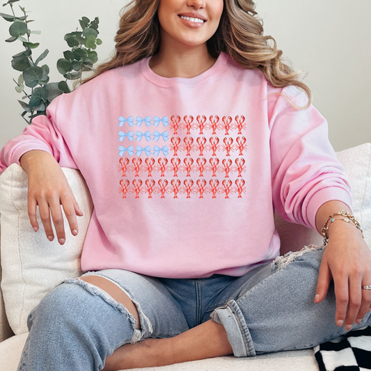 Customized Adult Light Pink Crewneck with American Flag made of blue bows and red lobsters. Perfect for 4th of July Ranging in sizes youth Small to adult 4X also comes in matching hoodies and crewnecks.