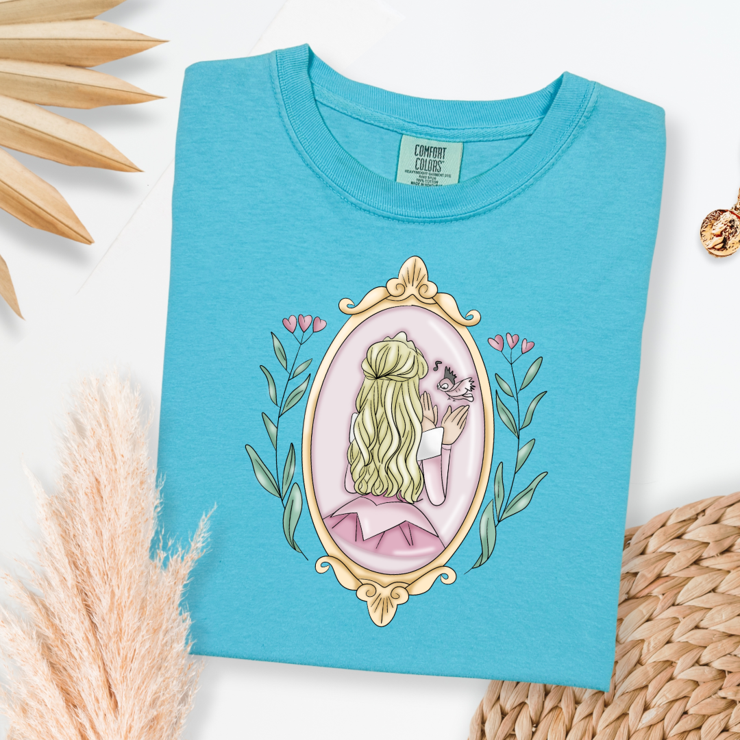 Customized comfort colors lagoon blue Graphic tee Disney Princess sleeping beauty/Aurora back silhouette in a gold mirror with flower vines up the side. Designs are available in Adult and youth graphic tees as well as youth and adult crewnecks and adult hoodies. 