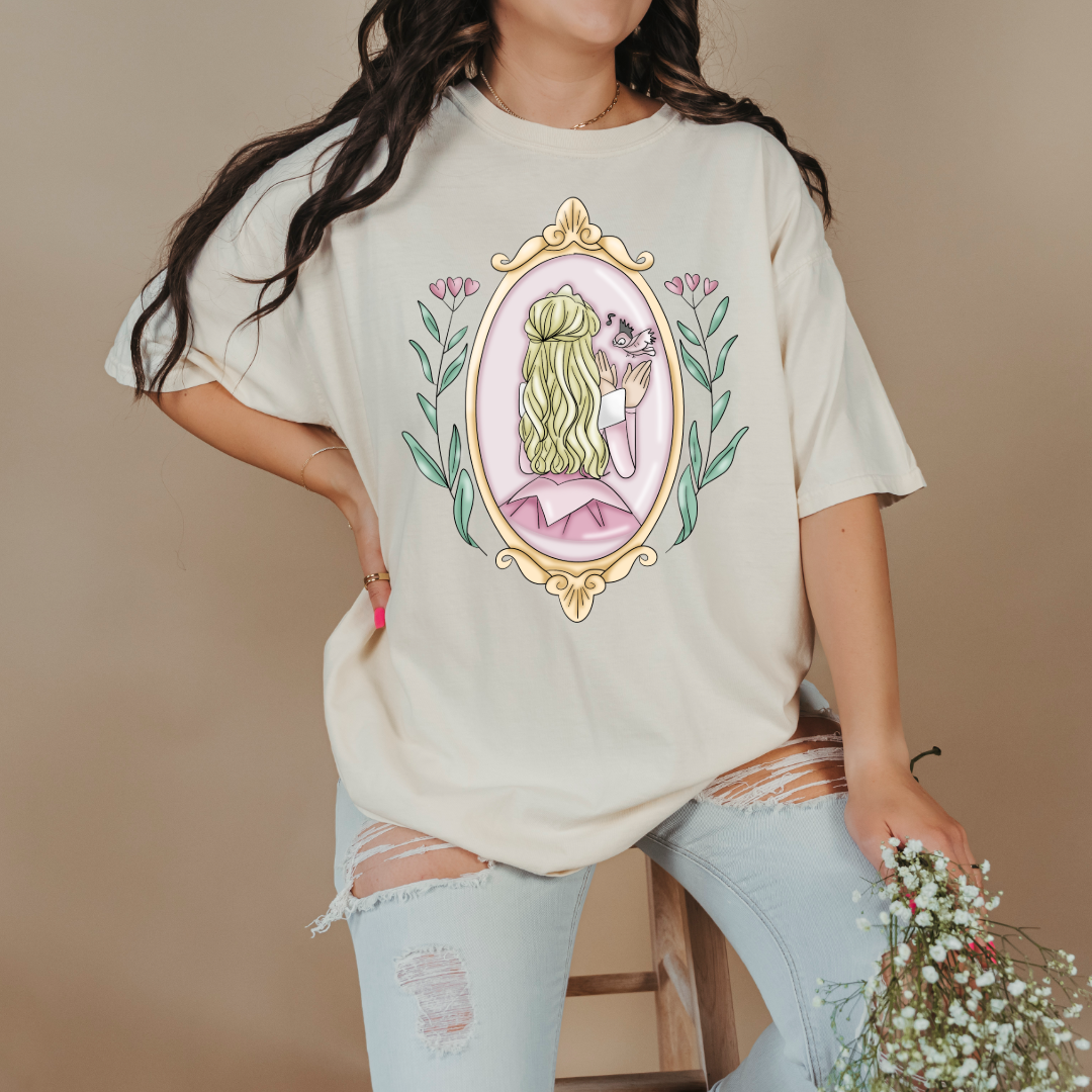 Customized comfort colors Ivory Graphic tee Disney Princess sleeping beauty/Aurora back silhouette in a gold mirror with flower vines up the side. Designs are available in Adult and youth graphic tees as well as youth and adult crewnecks and adult hoodies. 