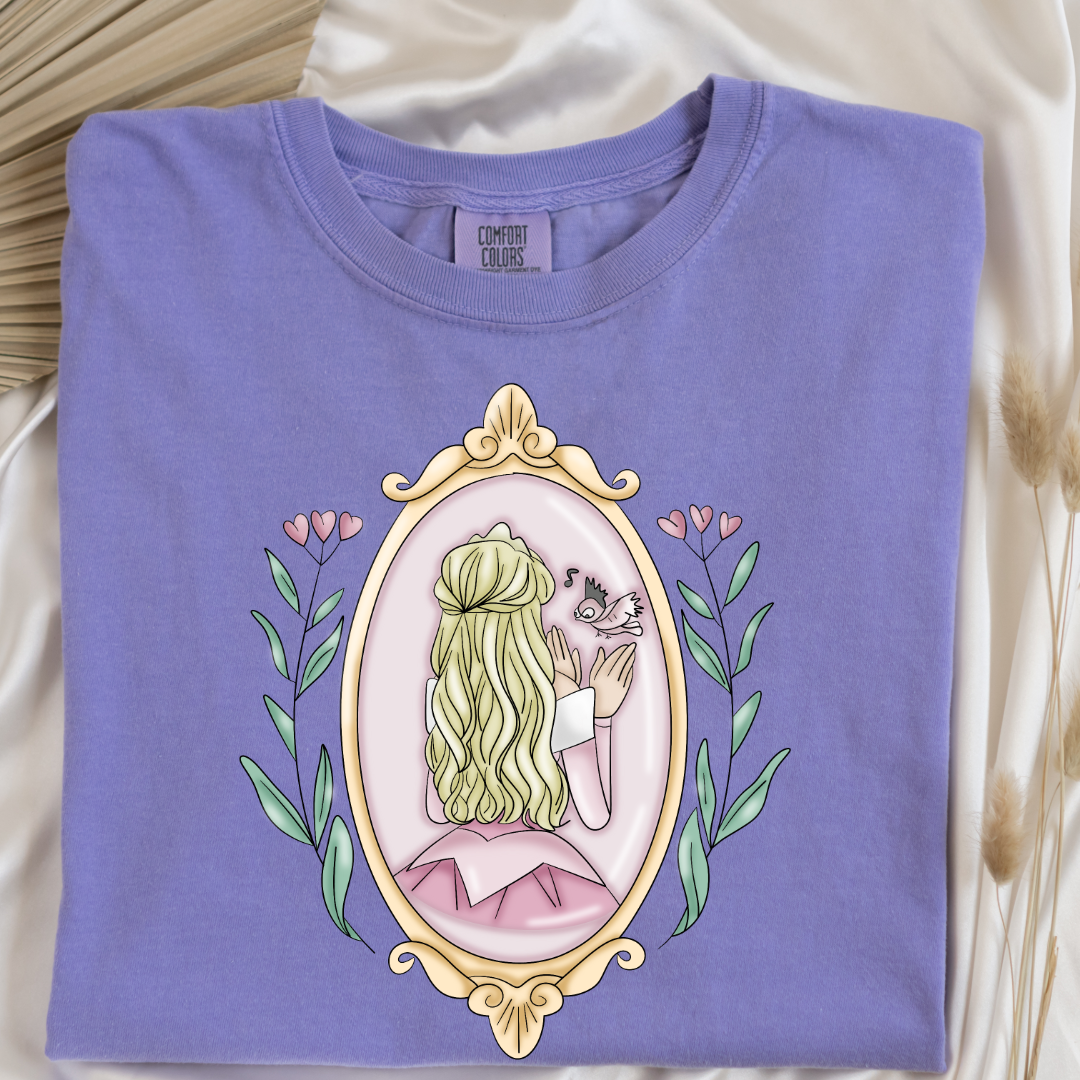 Customized comfort colors violet Graphic tee Disney Princess sleeping beauty/Aurora back silhouette in a gold mirror with flower vines up the side. Designs are available in Adult and youth graphic tees as well as youth and adult crewnecks and adult hoodies. 