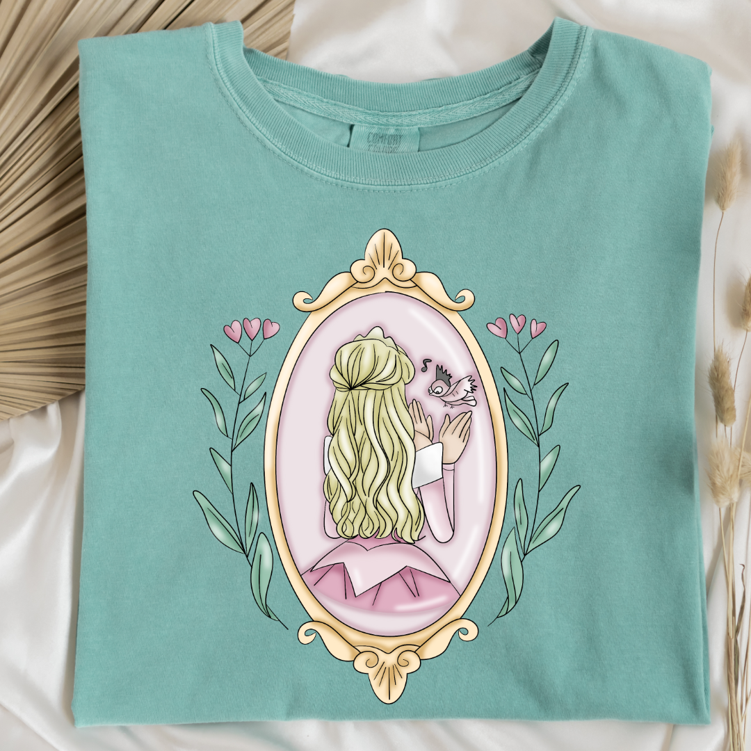 Customized comfort colors chalky mint Graphic tee Disney Princess sleeping beauty/Aurora back silhouette in a gold mirror with flower vines up the side. Designs are available in Adult and youth graphic tees as well as youth and adult crewnecks and adult hoodies. 