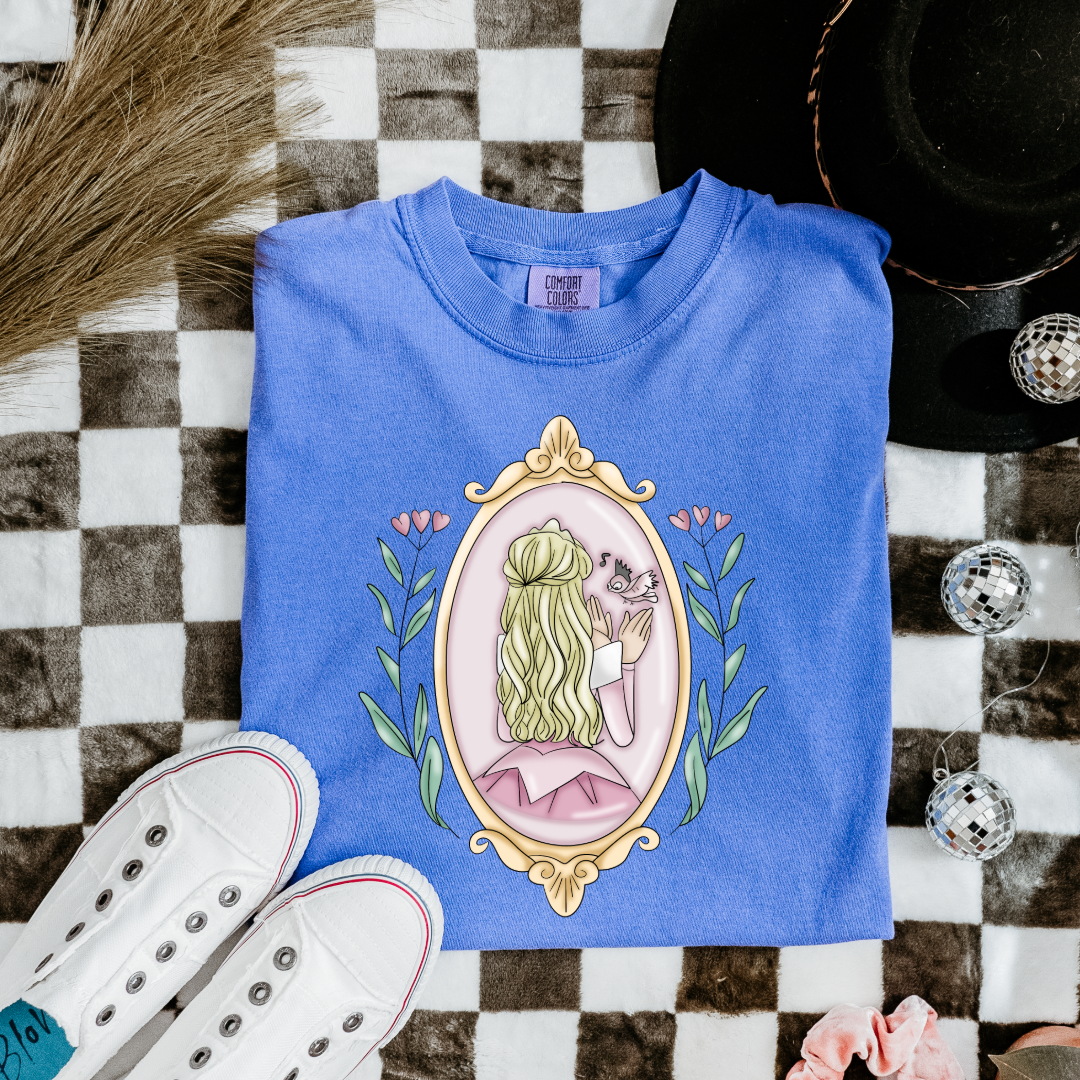 Customized comfort colors flo blue Graphic tee Disney Princess sleeping beauty/Aurora back silhouette in a gold mirror with flower vines up the side. Designs are available in Adult and youth graphic tees as well as youth and adult crewnecks and adult hoodies. 