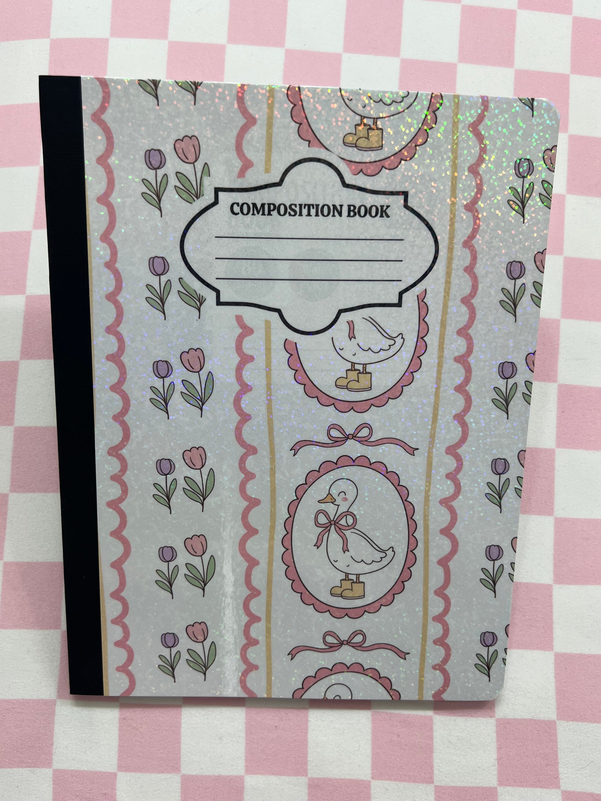 Composition book with decorative cover on a pink and white checkered background