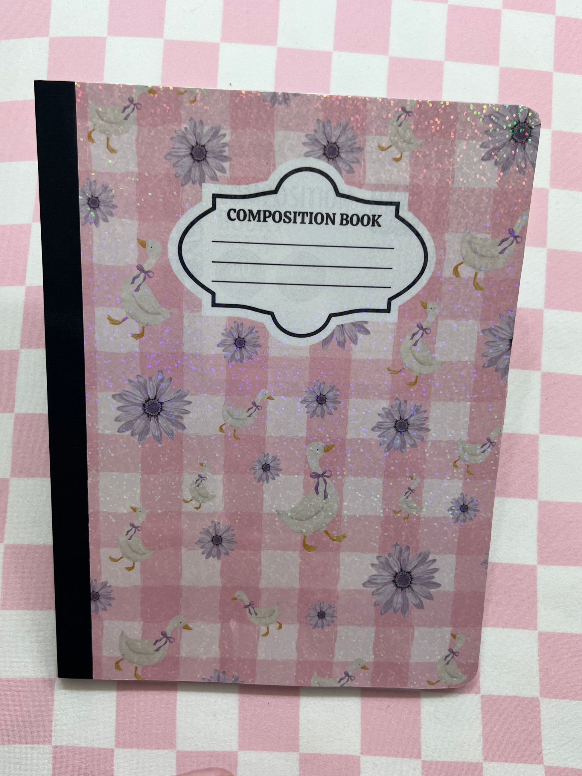 Composition book with floral and duck pattern on a pink and white checkered background