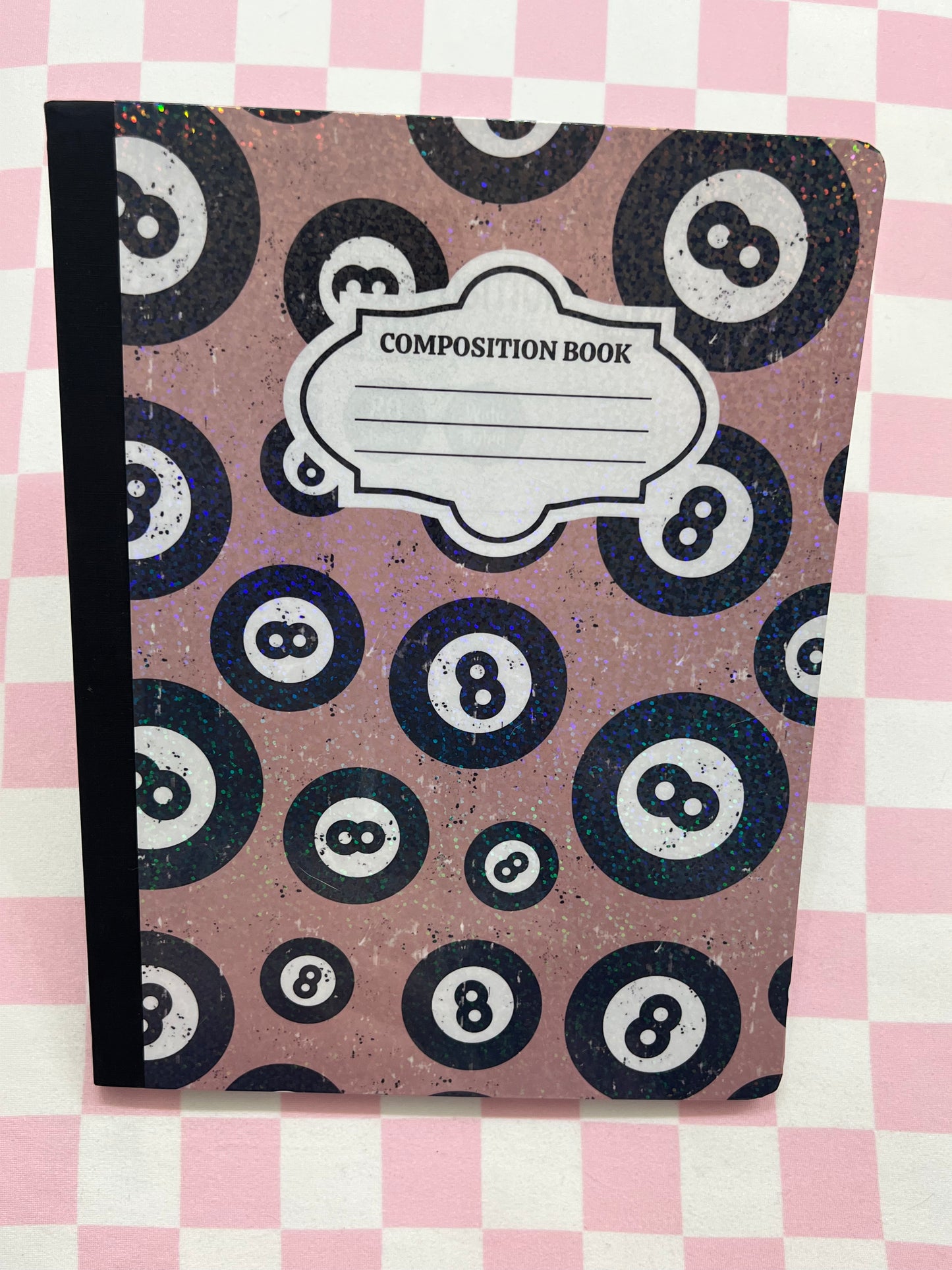 Composition book with billiard ball pattern on a pink and white checkered background
