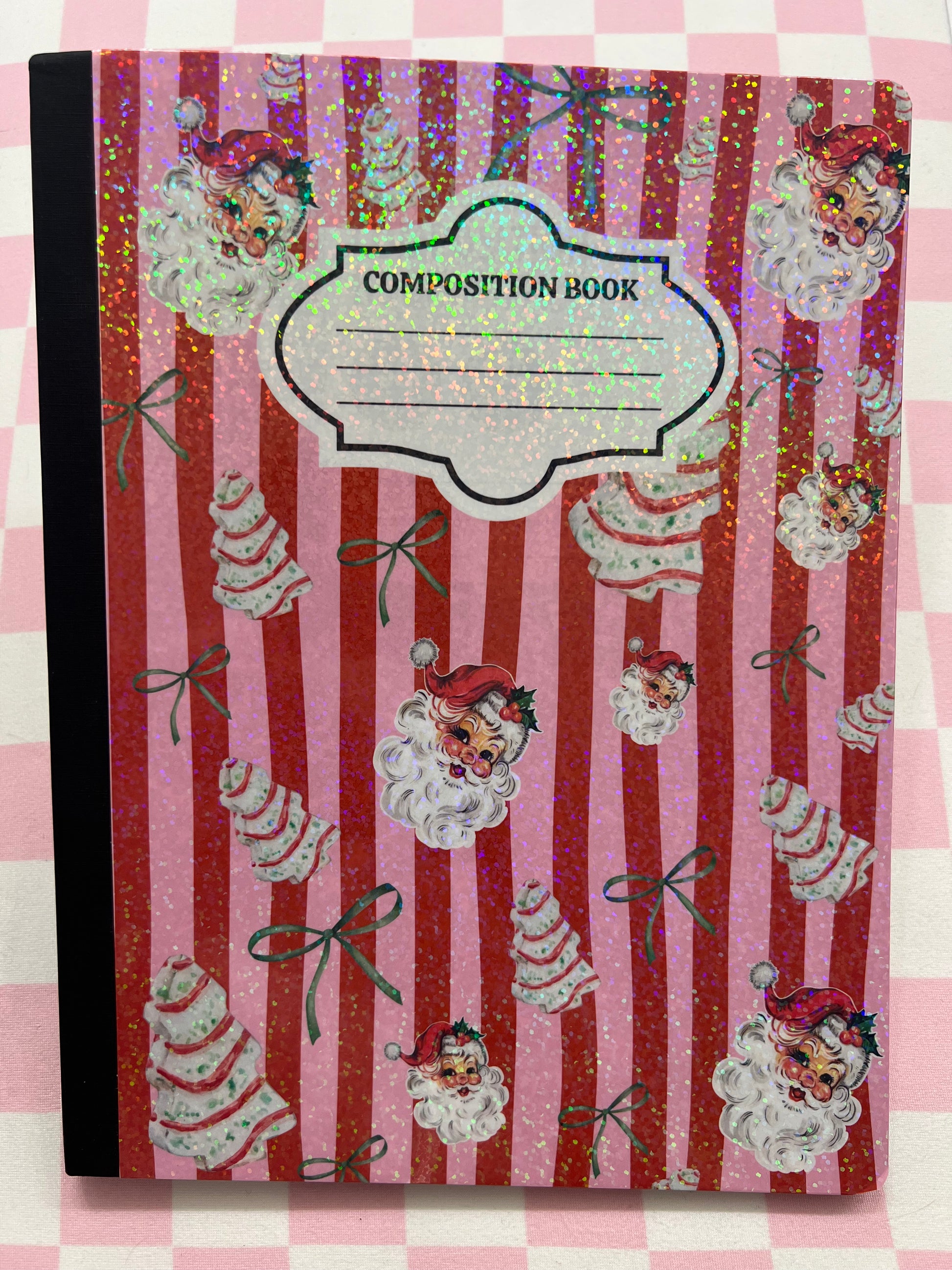 Composition book with decorative cover featuring cartoon characters and cake designs on a striped background.