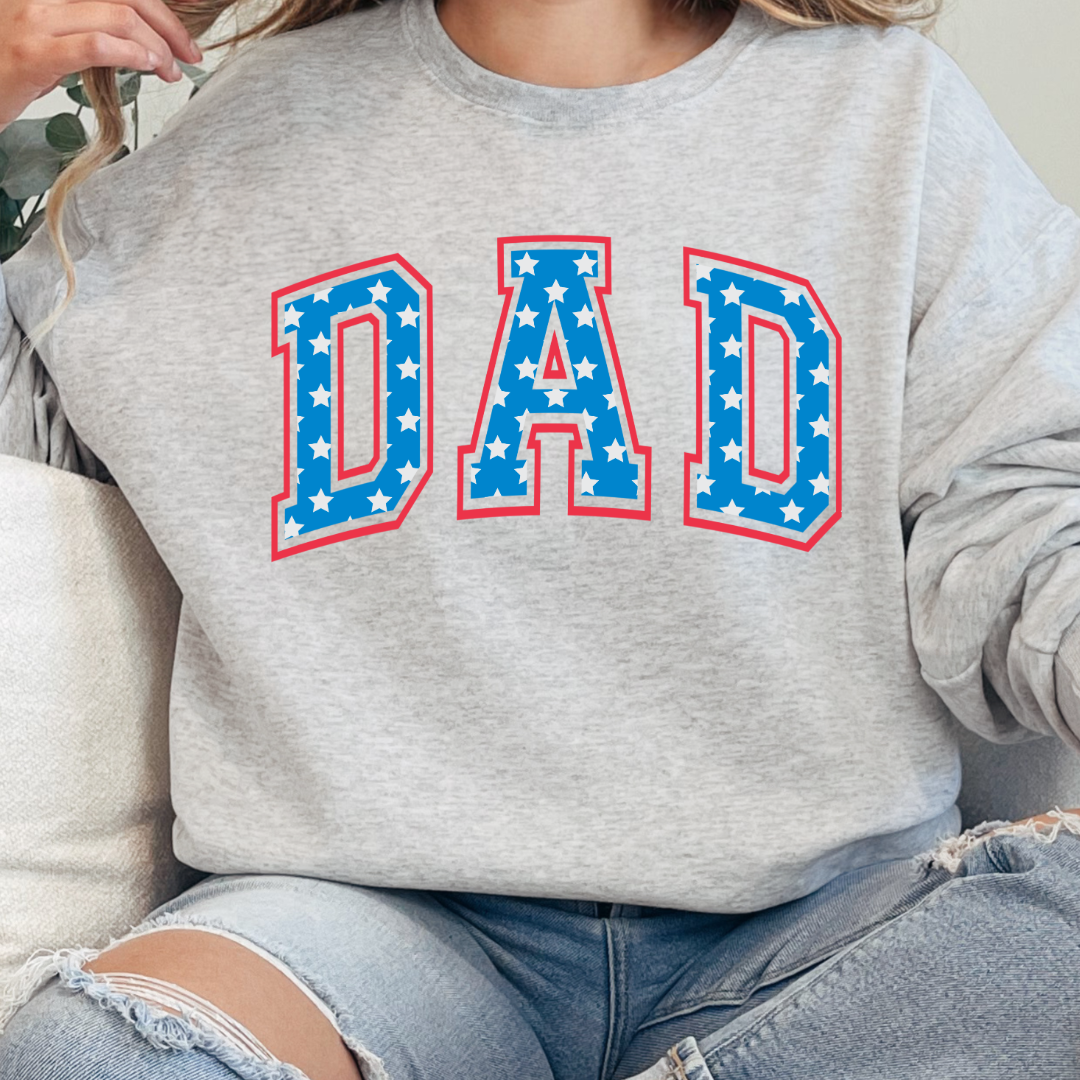 Customized adult Grey Crewneck  with Seasonal 4th of July University style Font DAD blue with white stars outlined un red , This style is available in adult  Graphic Tees as well as adult crewnecks and hoodies .Available In DAD, MAMA and MINI. 