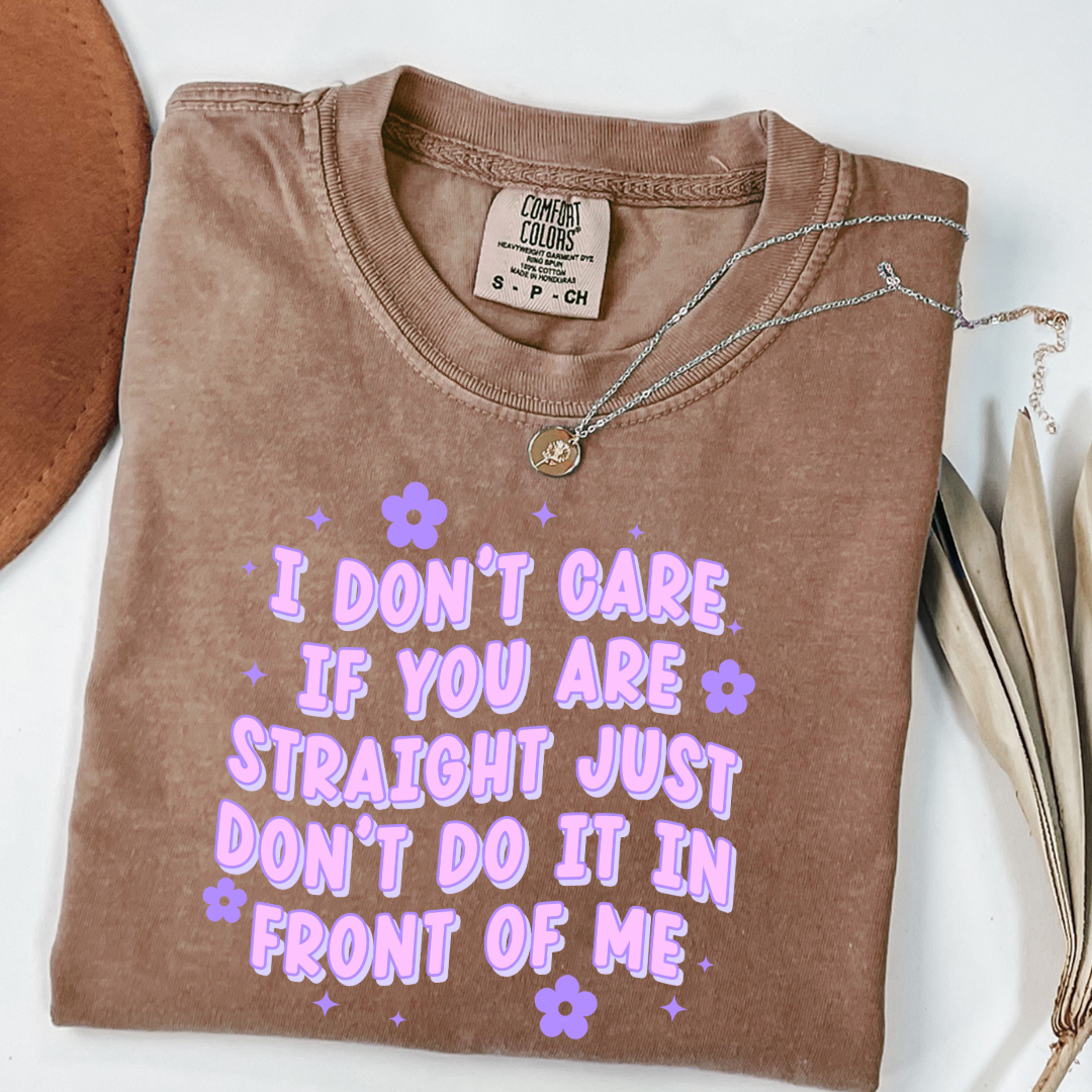 Customized Adult Comfort Colors Espresso brown Graphic Tee Quoted " I don't care if you're straight just don't do it in front of me.  Purple bubble letters with flowers spread out Matching Adult Crewnecks available Perfect for Pride.