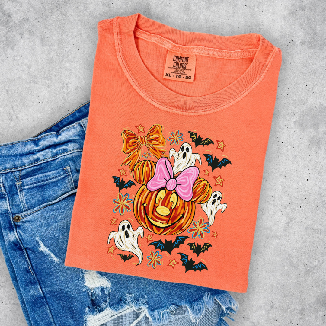 Youth Comfort Colors Melon Orange Graphic Tee with Dimensional Minnie Mouse pumpkin head with ghosts, bows and bats. This Design Is available in Youth sizes Small through XL. Mickey Mouse available as well 