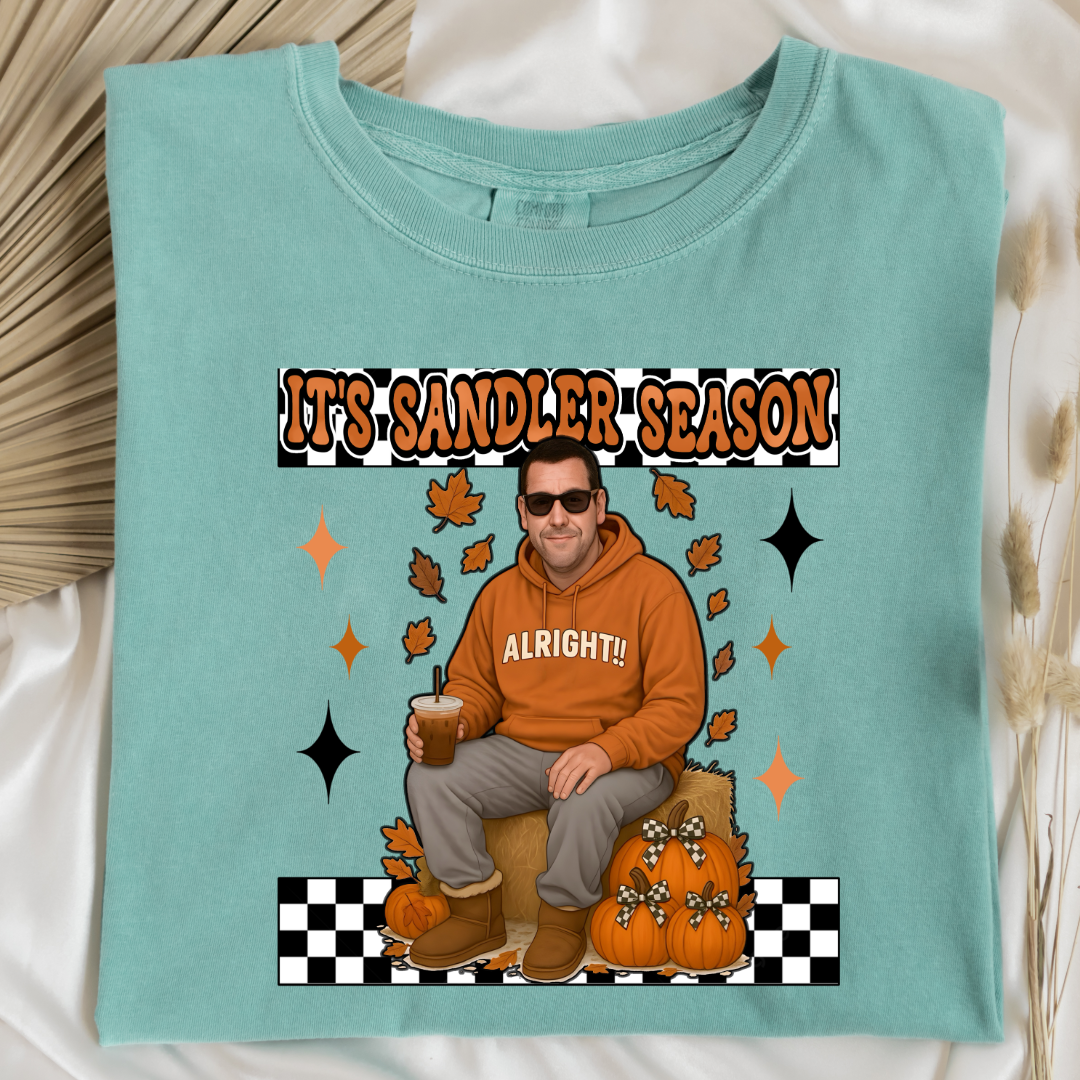 Comfort Colors Chalky Mint Adult Graphic Tee with Adam Sandler on the front sitting on a hay bale stack with a coffee in hand wearing UGGS and checker board its Sandler season. Design available in graphic tees as well in Adult sizing ranging from Small to 4X.