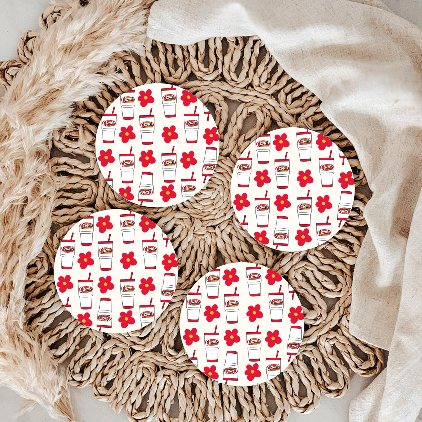 Round woven placemats with red floral and drink pattern on a textured surface