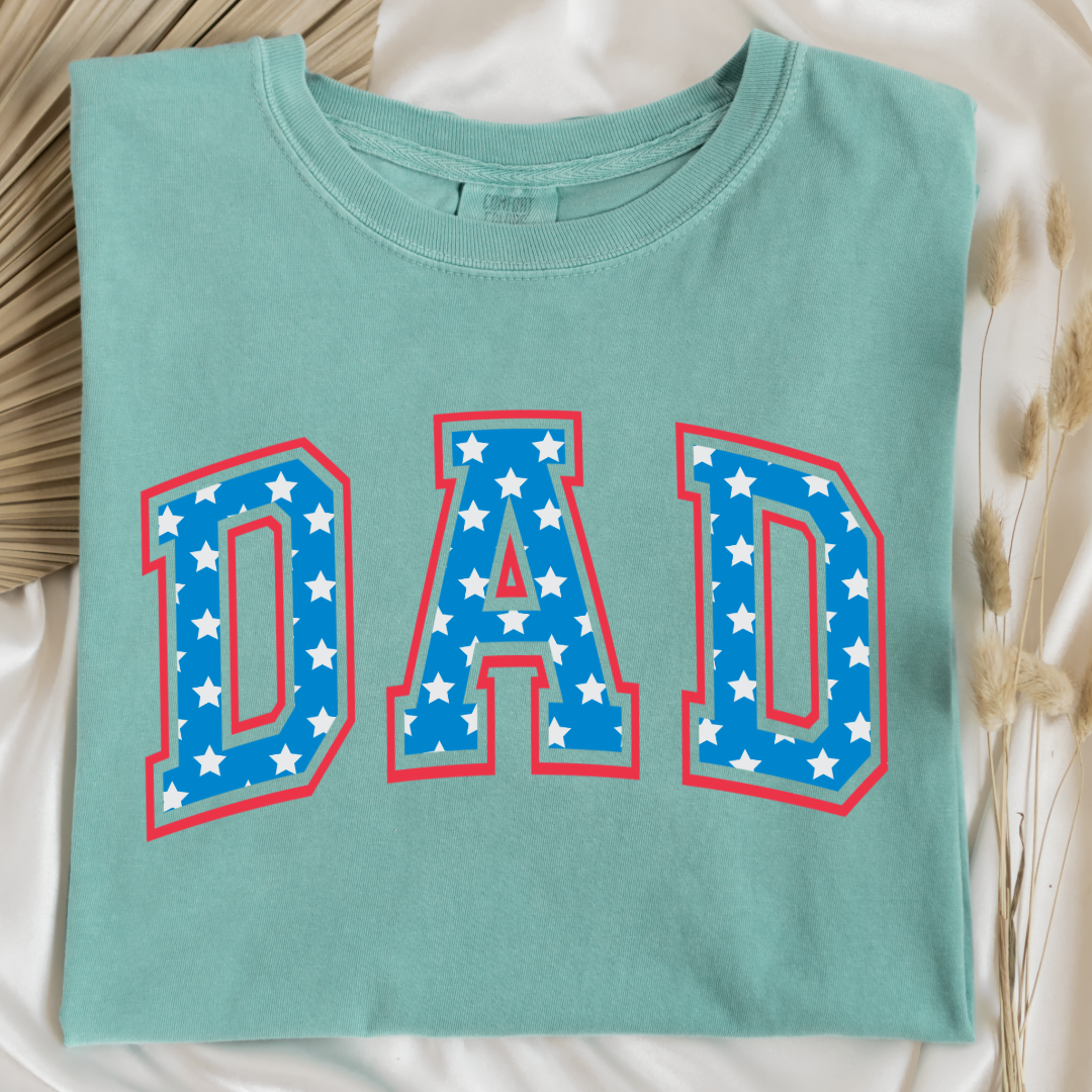 Customized adult Comfort Colors Chalky Mint Graphic Tee  with Seasonal 4th of July University style Font DAD blue with white stars outlined un red , This style is available in adult  Graphic Tees as well as adult crewnecks and hoodies .Available In DAD, MAMA and MINI. 
