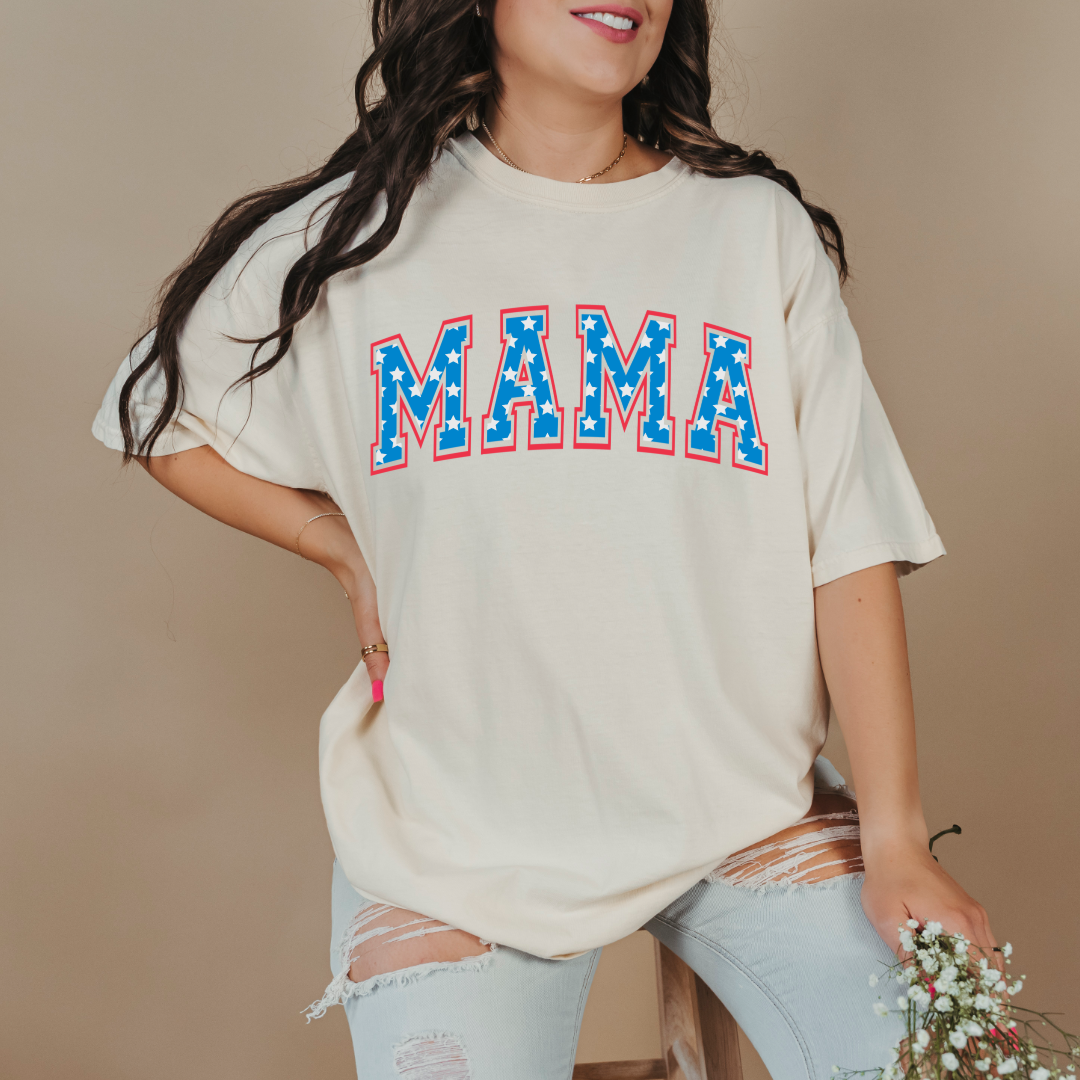Customized adult Comfort Colors Ivory Standing Graphic Tee  with Seasonal 4th of July University style Font MAMA blue with white stars outlined un red , This style is available in adult  Graphic Tees as well as adult crewnecks and hoodies .Available In DAD, MAMA and MINI. 