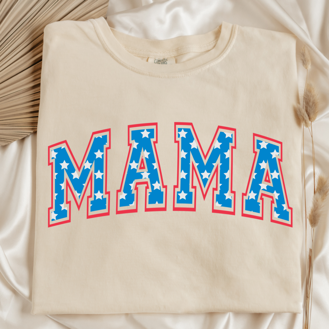 Customized adult Comfort Colors Ivory Folded Graphic Tee  with Seasonal 4th of July University style Font MAMA blue with white stars outlined un red , This style is available in adult  Graphic Tees as well as adult crewnecks and hoodies .Available In DAD, MAMA and MINI. 